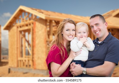 Happy Young Military Family Outside Their New Home Framing At The Construction Site.