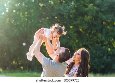 Happy Young Mixed Race Ethnic Family Walking In The Park.