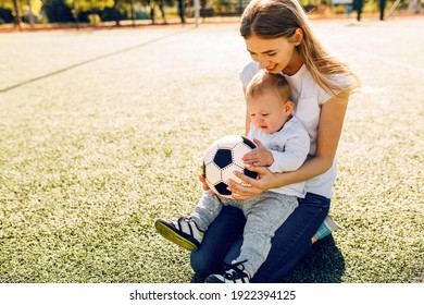 Happy Young Mom With Son Play Soccer On The Field, Outdoors
