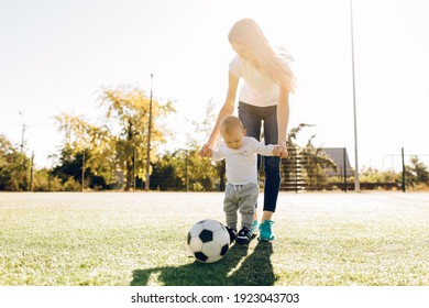 Happy Young Mom With Son Play Soccer On The Field, Outdoors