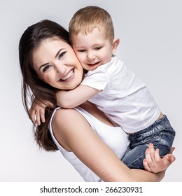 Happy Young Mother With A Child On Light Grey Background