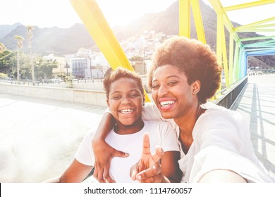 Happy Young Mother Having Fun With Her Child In Summer Sunny Day - Son Taking Selfie With His Mum Outdoor - Family Lifestyle, Motherhood, Love And Technology Concept - Main Focus On Woman Face