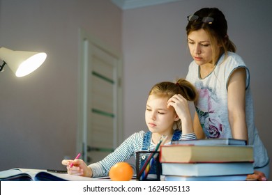 Happy Young Mother Helping Her Daughter While Studying At Home Getting Ready For School