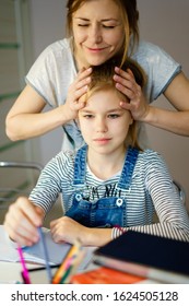 Happy Young Mother Helping Her Daughter While Studying At Home Getting Ready For School