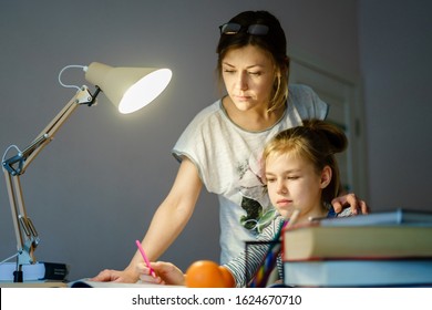 Happy Young Mother Helping Her Daughter While Studying At Home Getting Ready For School