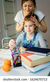 Happy Young Mother Helping Her Daughter While Studying At Home Getting Ready For School