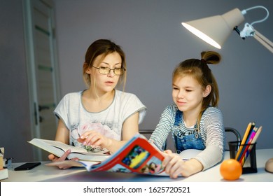 Happy Young Mother Helping Her Daughter While Studying At Home Getting Ready For School