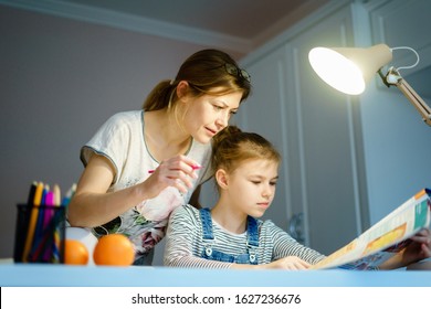 Happy Young Mother Helping Her Daughter While Studying At Home Getting Ready For School