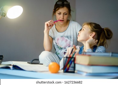 Happy Young Mother Helping Her Daughter While Studying At Home Getting Ready For School