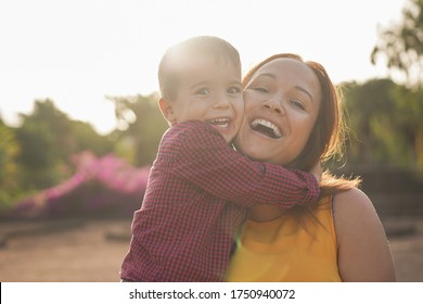 Happy Young Mother Laughing With Her Son In Her Arms - Young Mother And Child In A Nature Park Enjoy The Time Together - Mother And Child Love 