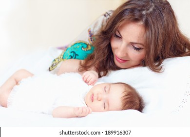 Happy Young Mother Near Sleeping Baby Girl