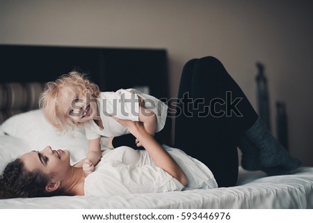 Similar – Relaxed mother and sons playing over the bed