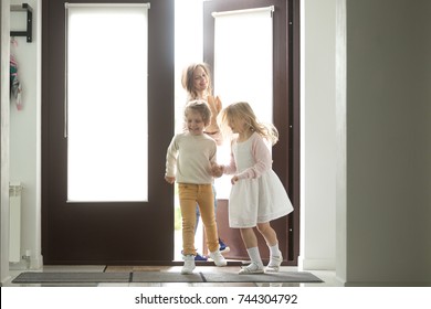 Happy Young Mother With Son And Daughter Opening Door Coming Back Home From Mall, Single Mom And Small Kids Returning To House Holding Paper Bag With Food, Family Grocery Shopping Together Concept 