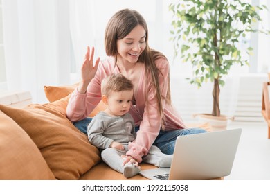 Happy Young Mother With Toddler Infant Newborn Baby Having Video Call Online Conference Conversation With Relatives Doctor Pediatrician, Having Consultation Remotely, Communicating With Friends