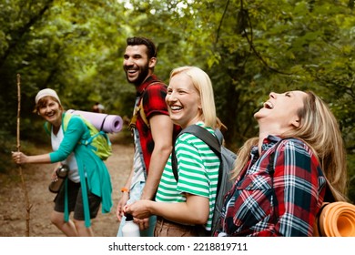 Happy young Multiethnic backpacker people walking in woods among green trees and laughing - Powered by Shutterstock