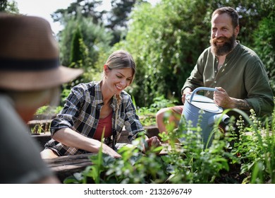 Happy Young And Old Farmers Working With Garden Tools Outdoors At Community Farm.