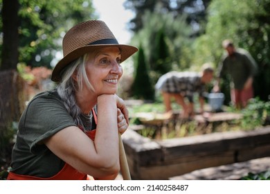 Happy Young And Old Farmers Working With Garden Tools Outdoors At Community Farm.