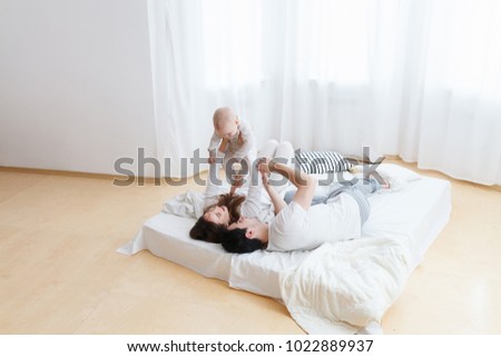 Similar – Happy boy jumping and playing over the bed with his family in a relaxed morning. Weekend family leisure time concept.