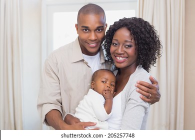 Happy young parents spending time with baby at home in the living room - Powered by Shutterstock