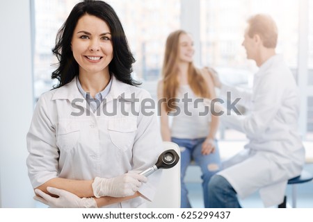 Happy young patient having conversation with dermatologist the hospital