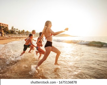 Happy young peaple having fun at beach on sunny day. Smiling teens on vacation - Powered by Shutterstock