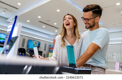 Happy young people buying new smartphone in mobile shop. Technology device shopping concept - Shutterstock ID 2140613571