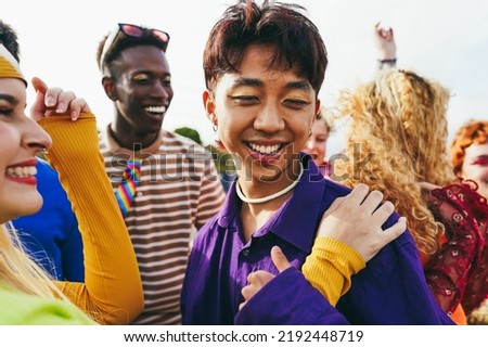 Happy young people dancing outdoor at festival event - Focus on asian man face
