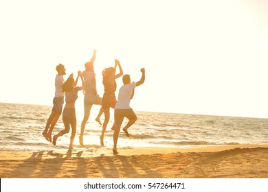 happy young people group have fun white running and jumping on beacz at sunset time - Shutterstock ID 547264471