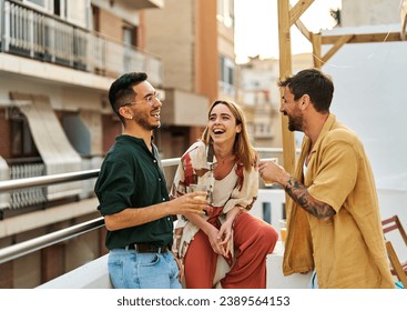 Happy young people having fun during a rooftop party during a summer holiday, standing on the rooftop terrace talking, eating and drinking, love, romance, relationship, flirting and youth culture  - Powered by Shutterstock