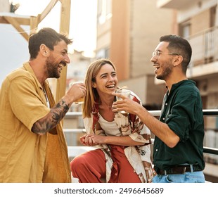 Happy young people having fun during a rooftop party during a summer holiday, standing on the rooftop terrace talking, eating and drinking, love, romance, relationship, flirting and youth culture  - Powered by Shutterstock