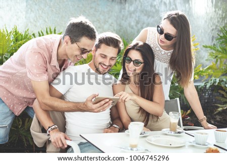 Similar – Young happy people looking tablet over table