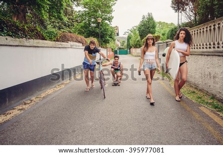 Happy young people having fun with skateboard and bicycle