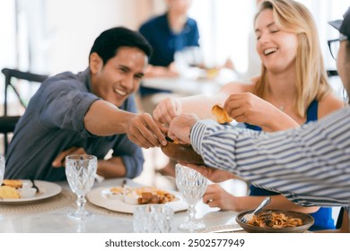 Happy young people laughing enjoying meal having fun sitting together at restaurant table, diverse friends person share lunch at meeting, talking and chatting together in holiday lifestyle - Powered by Shutterstock