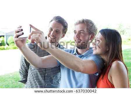 Happy young people photographing for social network
