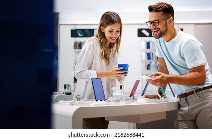 Happy young people shopping new mobile phone in a store. People technology device new concept - Shutterstock ID 2182688441