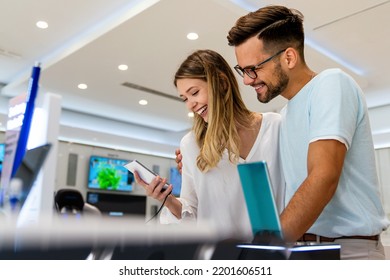 Happy young people shopping new mobile phone in a store. People technology device new concept - Shutterstock ID 2201606511