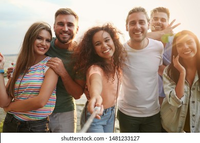 Happy young people taking selfie outdoors on sunny day - Powered by Shutterstock