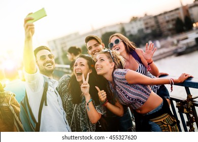 Happy young people taking selfies in city