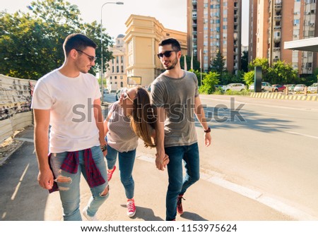 Happy young people walking down the city street and having fun. Young and carefree concept.