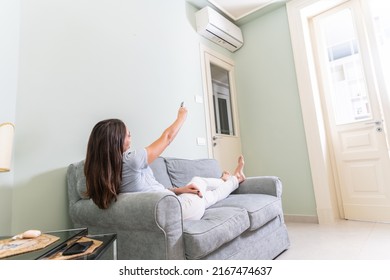 Happy Young Person Holding Remote Control Relaxing Under The Air Conditioner - Holding Remote Control Switch On Conditioning