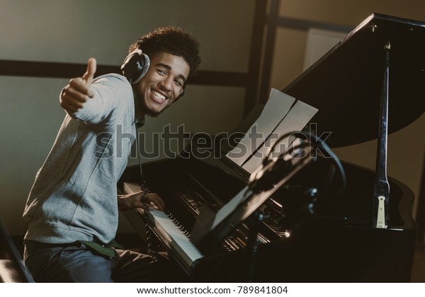 happy young piano\
player showing thumb up