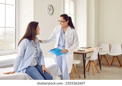 Happy young pregnant woman talking with her gynecologist doctor in hospital or medical clinic. Obstetrician doctor consulting female patient expecting a baby about pregnancy during check up. - Powered by Shutterstock