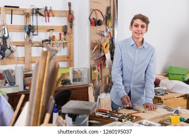 Happy Young Pupil Working With  Wood Plank In Class

