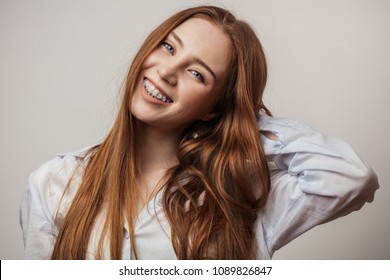 Happy young red-haired woman in braces smiling on white background looking at camera - Shutterstock ID 1089826847
