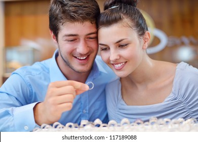 Happy Young Romantic Couple In Love Buy Jewelry Ring In Luxury Store