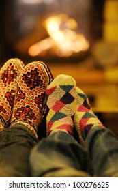 家で冬の季節に暖炉の前でくつろぐソファーと幸せな若い夫婦の写真素材