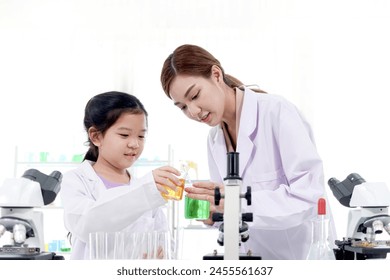 Happy young scientist kid girl in lab coats using lab equipment for study in school laboratory. Asian female teacher teaching schoolgirl child to do science experiments. Kid learning science education - Powered by Shutterstock