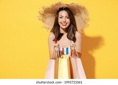 Happy Young Sexy Woman Slim Body Wear Striped Red Blue Swimsuit Straw Hat Hold Package Bags After Shopping Isolated On Vivid Yellow Color Background Studio. Summer Hotel Pool Sea Rest Sun Tan Concept