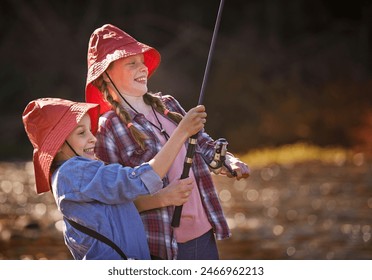 Happy, young sisters and fishing together in river for relax, fun hobby and outdoor adventure in nature. Excited, girls or children and catching fish in lake with bucket hat for vacation activity - Powered by Shutterstock