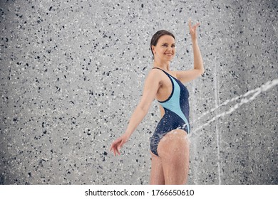 Happy Young Slim Caucasian Female Patient Wearing A Stylish One-piece Swimsuit During The Hydrotherapy Treatment